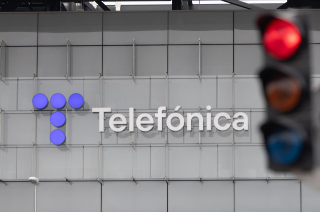 Archivo - Un semáforo en rojo frente a la sede de Telefónica