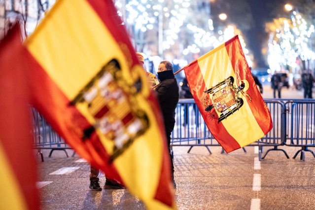 Varias personas con banderas españolas preconstitucionales celebra la entrada del año nuevo, en la calle Ferraz, a 1 de enero de 2024, en Madrid (España).
