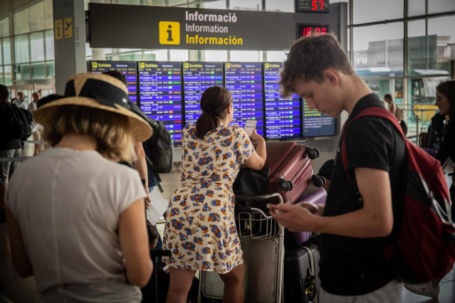 Archivo - Diferentes viajeros esperanfrente al panel de información de los vuelos de Salida del Aeropuerto 'Josep Tarradellas Barcelona-El Prat', durante la Huelga del personal de tierra de Iberia en Barcelona.
