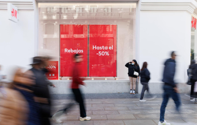 Archivo - Varias personas caminan frente a una tienda de H&M, a 3 de enero de 2023, en Madrid (España). Las marcas de ropa Mango y H&M se han adelantado este año y han colgado los carteles de rebajas antes que otras marcas tanto en sus tiendas online como