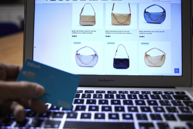 Archivo - Una persona compra con su tarjeta de crédito durante la semana en que han dado comienzo las Rebajas Online