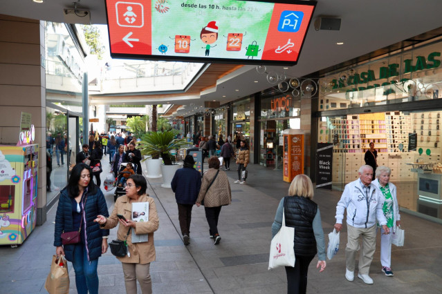 Archivo - Varias personas van de compras en un centro comercial