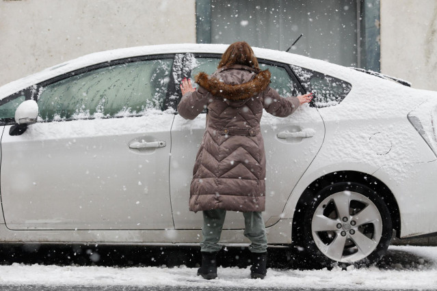 Una mujer limpia su coche de la nieve en Pedrafita do Cebreiro, a 5 de enero de 2024, en Pedrafita do Cebreiro, Lugo, Galicia (España).