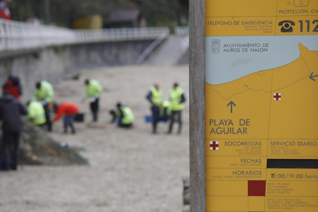 Operarios de TRAGSA recogen pellets de plástico, en la playa de Aguilar, a 9 de enero de 2024, en Muros de Nalón, Asturias (España).