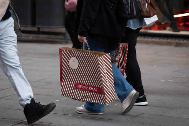 Archivo - Una persona sujeta bolsas con compras durante la campaña de Navidad, a 1 de diciembre de 2023, en Barcelona, Catalunya (España).