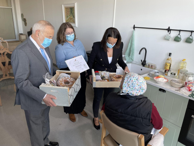 La consejera de Bienestar Social y Familia del Gobierno de Aragón, Carmen Susín, saluda a un residente en el taller de cocina.