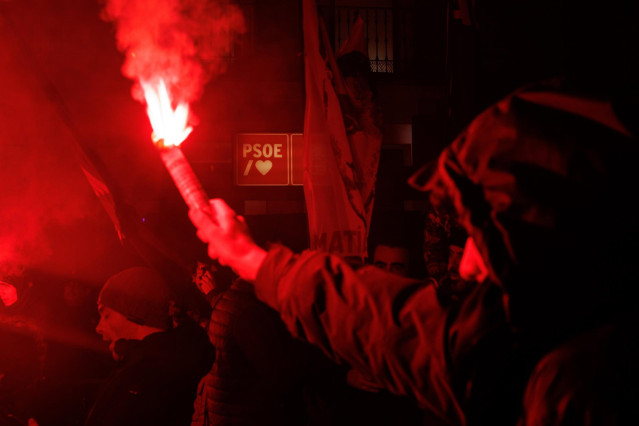 Decenas de personas con bengalas, durante una manifestación de la Falange Española, frente a la sede de Ferraz, a 9 de febrero de 2024, en Madrid (España).