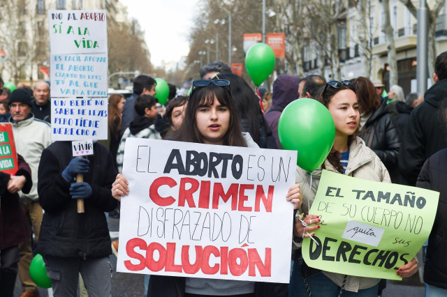 Varias personas protestan con carteles durante la marcha por la vida, a 10 de marzo de 2024, en Madrid (España).