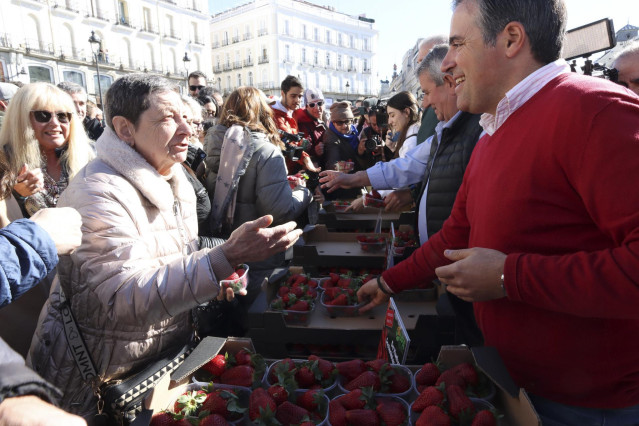 El secretario general de UPA Andalucía, Cristóbal Cano, reparte tarrinas de fresas en la Puerta del Sol de Madrid.