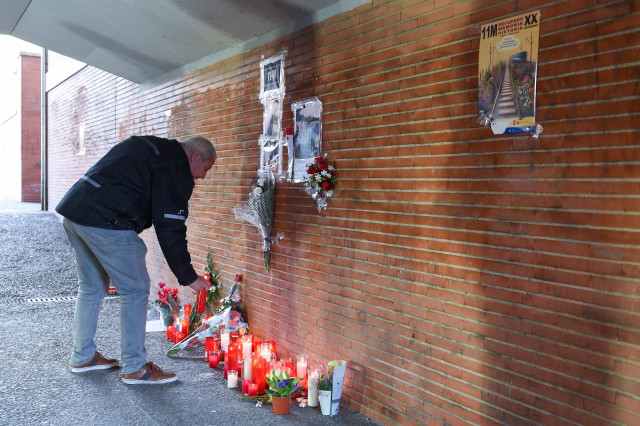 Varias personas durante una concentración de homenaje a las víctimas del atentado del 11M en su 20 aniversario, frente al monumento conmemorativo ‘Peridis’, en la estación de Renfe de ‘El Pozo’.