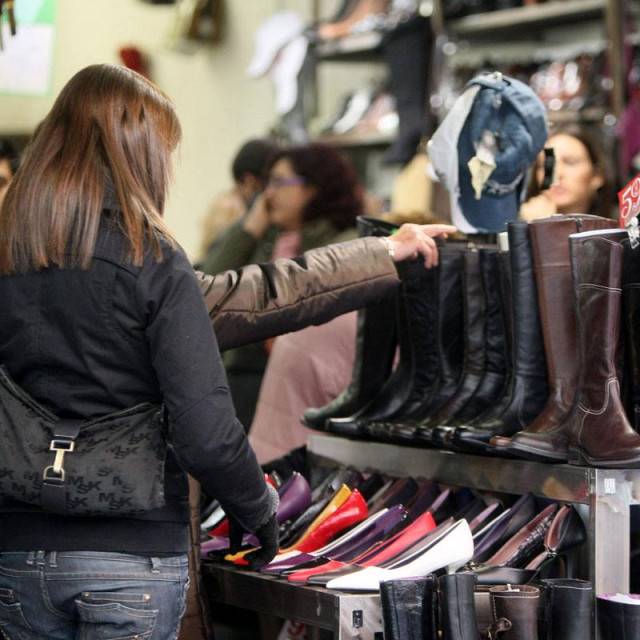 Archivo - Consumidor comprando botas en una tienda.