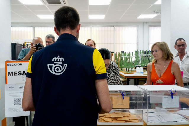 Archivo - Un cartero llega al colegio electoral con el voto por correo