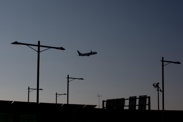 Archivo - Un avión sobrevuela el Aeropuerto de Barcelona-El Prat