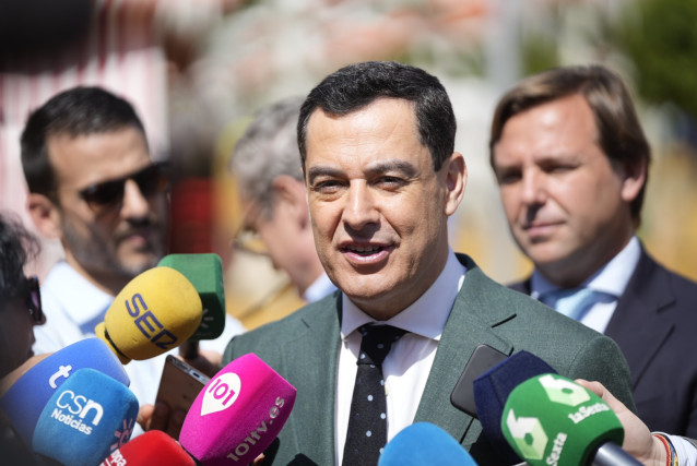 El presidente de la Junta de Andalucía, Juanma Moreno, atiende a los medios en la Feria de Sevilla.