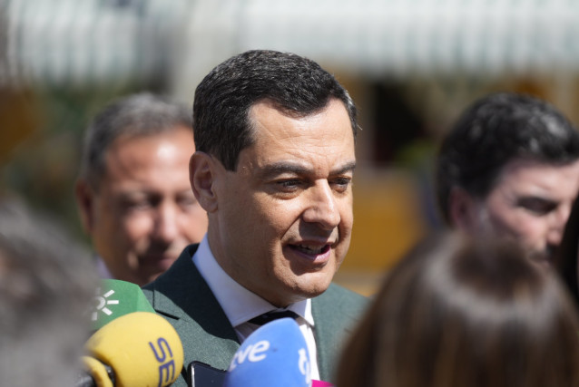 El presidente de la Junta de Andalucía, Juanma Moreno, atiende a los medios en la Feria de Sevilla.