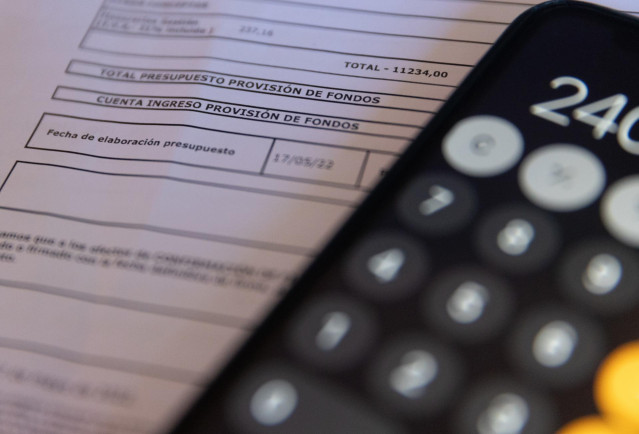 Archivo - Una calculadora y una escritura de compraventa de una hipoteca.