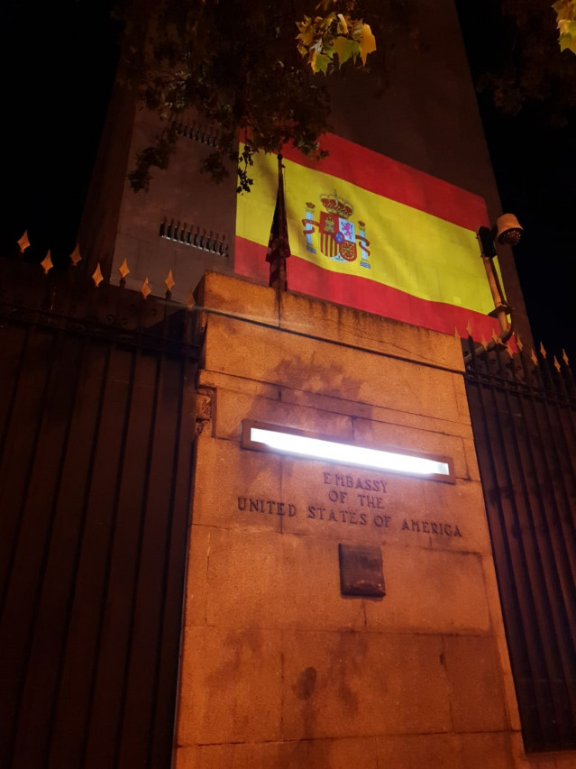 Archivo - La fachada de la embajada de EEUU en Madird se ilumina con la bandera de España.