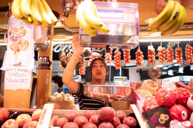 Archivo - Una persona trabaja en un puesto en el mercado de la Boquería.