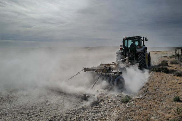 Archivo - Un tractor para arar la tierra en el campo de Belchite