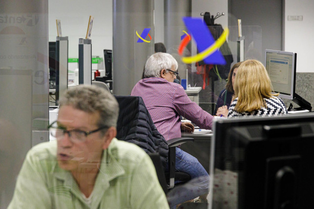 Archivo - Varias personas son atendidas en la Agencia Tributaria