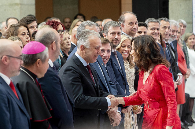 La presidenta de la Comunidad de Madrid, Isabel Díaz Ayuso (1d), saluda al ministro de Política Territorial y Memoria Democrática, Ángel Víctor Torres (4i), a su llegada a la entrega de Grandes Cruces de la Orden del Dos de Mayo, en la Real Casa de Correo