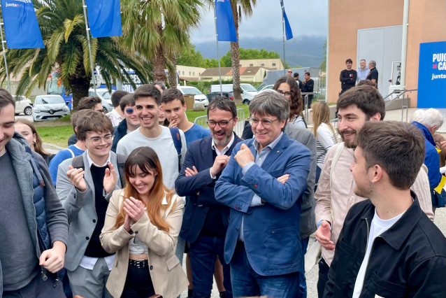 El portavoz de Junts, Josep Rius, y el candidato de Junts+ a las elecciones catalanas, Carles Puigdemont, con miembros de la Joventut Nacionalista de Catalunya (JNC).