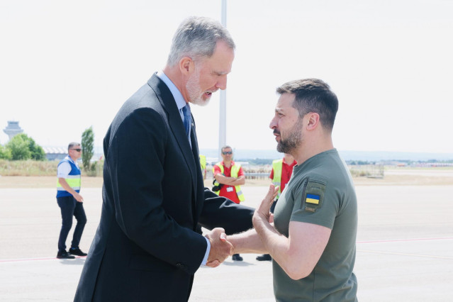 El Rey Felipe VI (i), saluda al presidente de Ucrania, Volodimir Zelenski (d), tras llegar al aeropuerto de Adolfo Suárez Madrid-Barajas