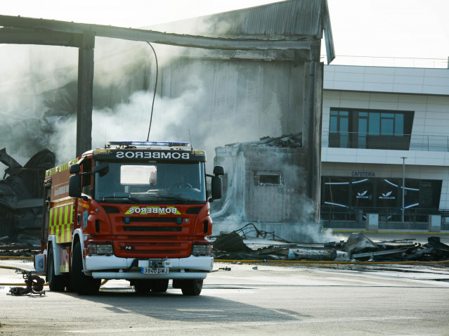 Los bomberos siguen con los trabajos para contener y enfriar la nave hortofrutícola incendiada en El Ejido (Almería).