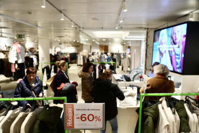 Archivo - Varias personas compran en el centro comercial