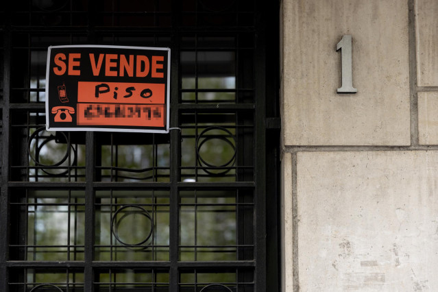 Archivo - Vista de un cartel de 'Se vende piso' en un portal de un edificio