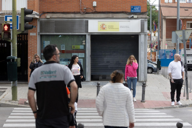 Varias personas frente a una oficina del Servicio Público de Empleo