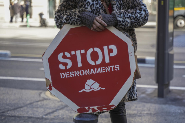 Archivo - Una persona sujeta un cartel de 'Stop desnonamients' durante una concentración de la Plataforma de Afectados por la Hipoteca (PAH)