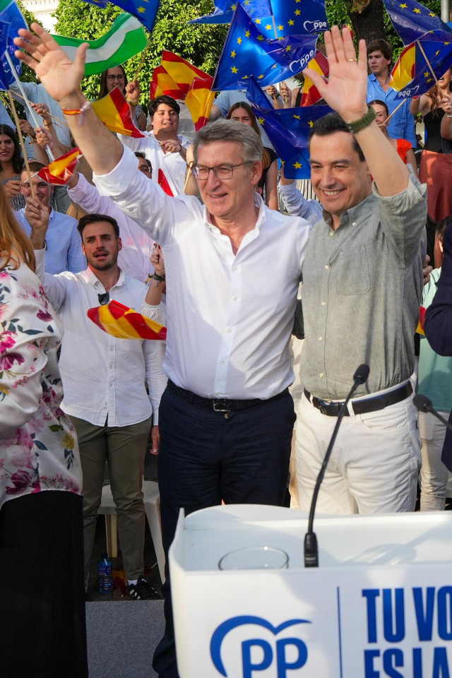 El presidente del PP, Alberto Núñez Feijóo (i), junto al presidente de la Junta de Andalucía, Juanma Moreno (d), durante un acto de campaña de su partido, en la plaza de San Gonzalo de Sevilla, a 05 de junio de 2024, en Sevilla, Andalucía (España). Feijóo