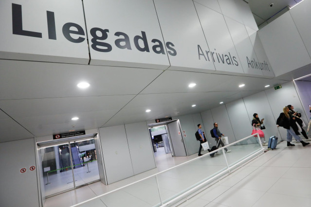 Archivo - Varios pasajeros en la terminal de llegadas de un aeropuerto
