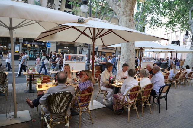Varias personas en una terraza durante una manifestación contra la masificación turística y por la vivienda digna, entre el Parc de ses Estacions y la plaza de España, a 25 de mayo de 2024, en Palma de Mallorca, Mallorca, Baleares (España).