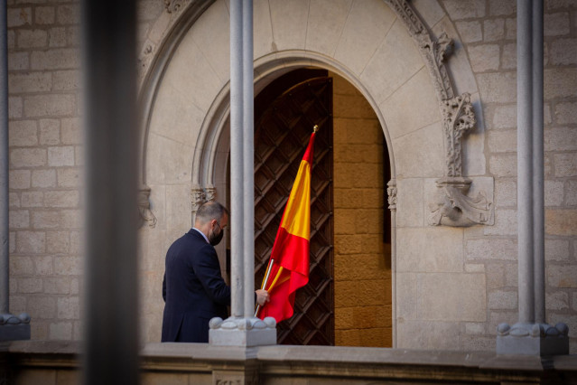 Archivo - Un hombre retira la bandera de España, a 15 de septiembre de 2021, en Barcelona, Catalunya (España).