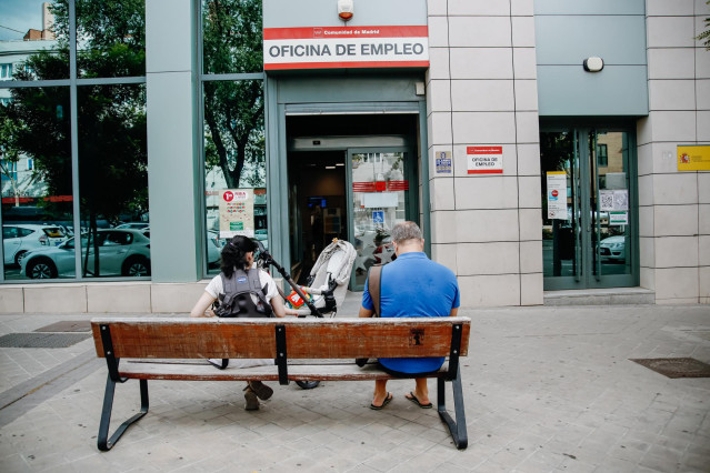 Archivo - Dos personas esperan fuera de una oficina de empleo de Madrid