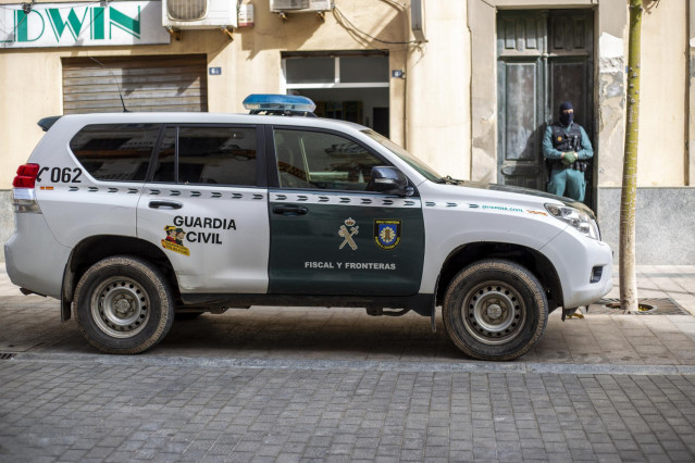 Archivo - Un vehículo y un agente de la Guardia Civil durante una operación de la Guardia Civil