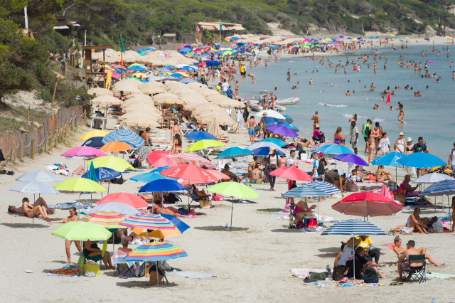 Archivo - Varias personas en la playa de Ses Salines, a 11 de julio de 2023, en Ibiza, Islas Baleares (España). Los datos de la Federación Empresarial Hotelera de las Pitiusas indican que todas las zonas turísticas de la isla de Ibiza registraron grandes