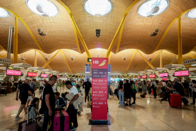 Archivo - Varios pasajeros esperan para obtener sus tarjetas de embarque y facturar su equipaje en la T4 del Aeropuerto Adolfo Suárez Madrid-Barajas, a 28 de agosto de 2022, en Madrid (España).