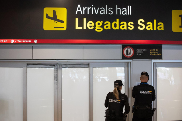 Archivo - Dos agentes de la Policía Nacional en la puerta de llegadas de la terminal T1 del Aeropuerto Adolfo Suárez Madrid Barajas.