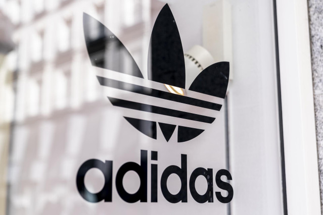 Archivo - Un letrero en el escaparte de una tienda de Adidas