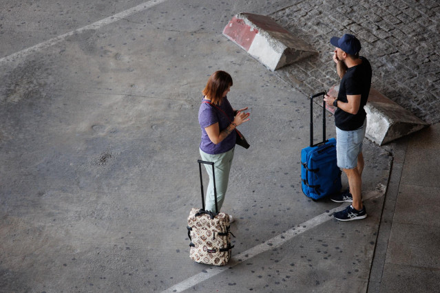 Archivo - Dos personas con maletas en la terminal T4 del Aeropuerto Adolfo Suárez Madrid-Barajas.