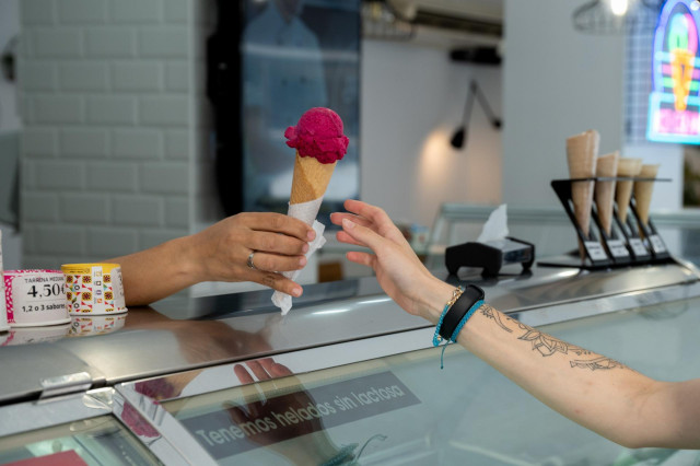 Archivo - Una mujer compra un helado