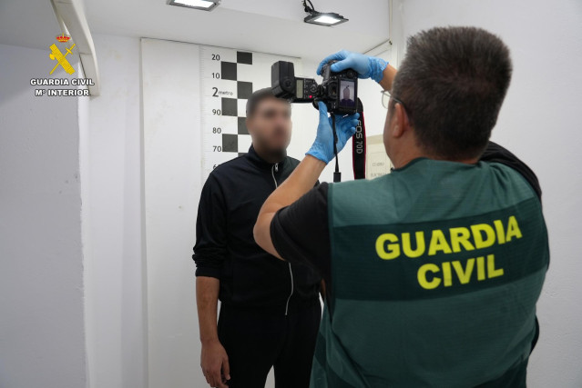 Un agente de la Guardia Civil toma fotografías al detenido, Karim E.B, acusado de ser el piloto de la narcolancha que mató a dos agentes en Barbate