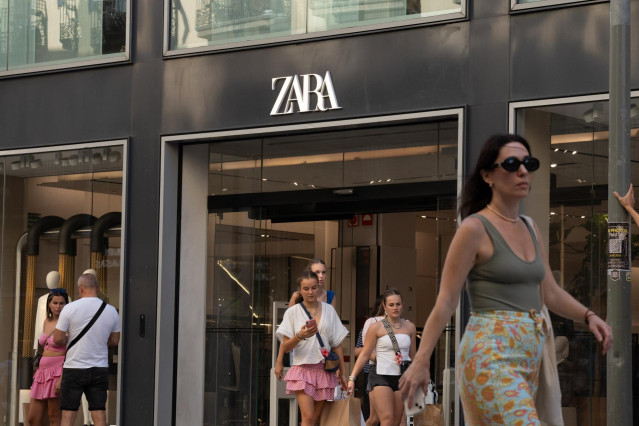 Varias personas pasan delante de una tienda Zara
