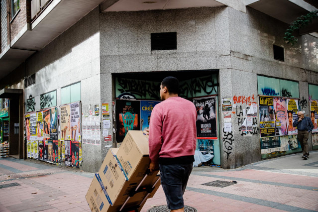 Archivo - Foto de archivo de un repartidor cargando con varias cajas.