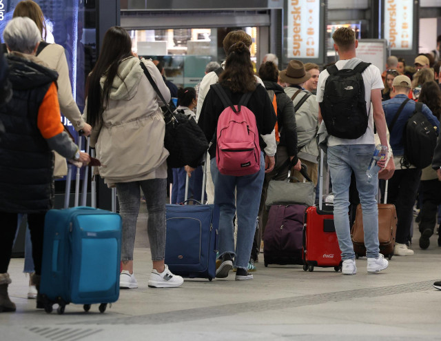 Archivo - Numerosas personas con maletas salen de viaje en la estación Almudena Grandes-Atocha