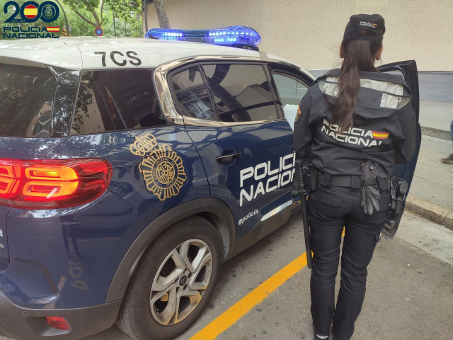 Archivo - Agente de la Policía Nacional junto a un vehículo