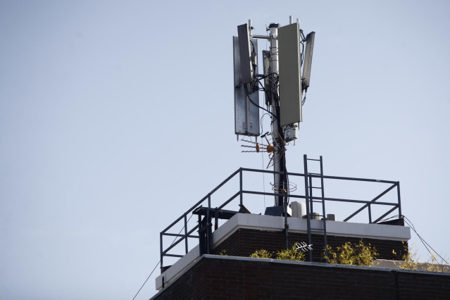Archivo - Imagen de una antena de telefonía en el tejado de una casa en la ciudad de Madrid.